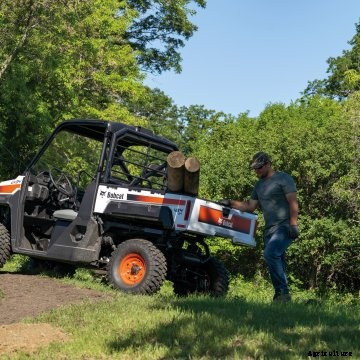 Farmer working on fence with Bobcat gas UTV