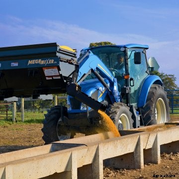Danuser Mega Mixer handling bucket on a New Holland tractor dispensing livestock feed