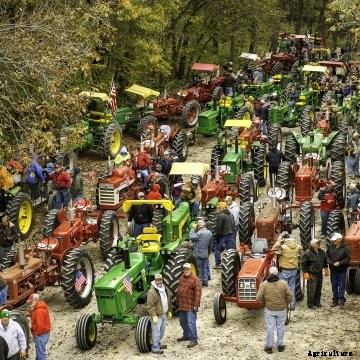 A plethora of antique tractors during a ride.