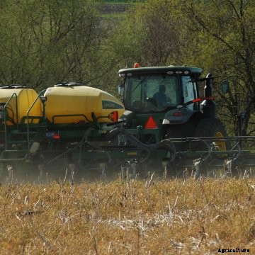 A farmer plants corn with John Deere equipment
