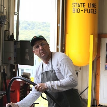 John Williams fills a barrel with the oil derived from his press