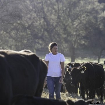 Meredith Ellis walking through a pasture.
